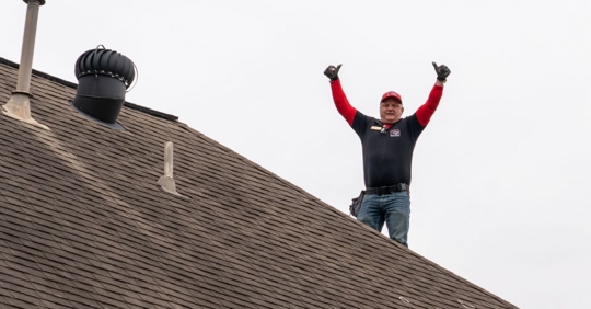 roofer standing on top of house